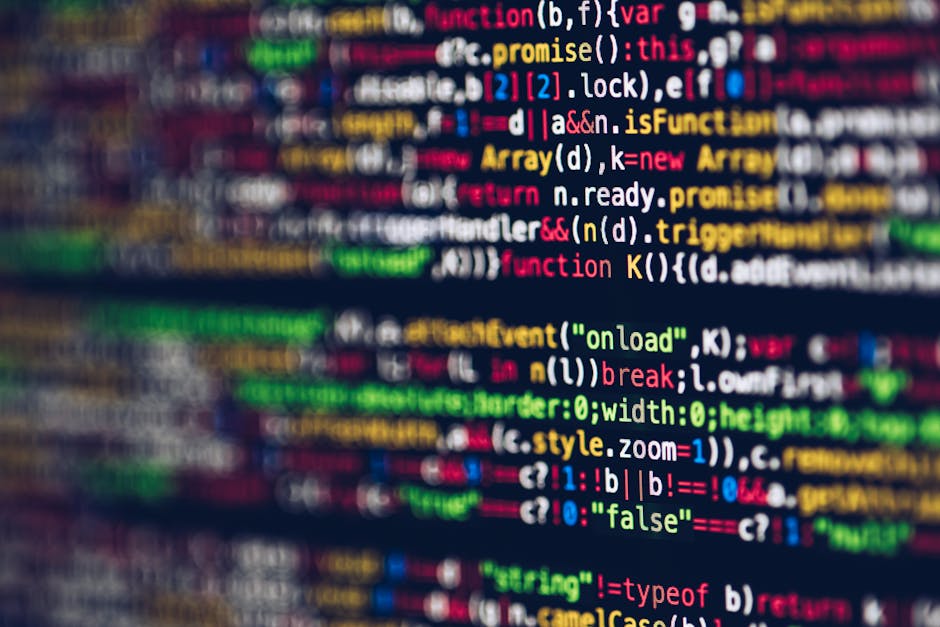 A close-up photograph of a computer screen displaying a colorful code editor with multiple lines of programming code. The code features syntax highlighting with various colors—including blue, red, g